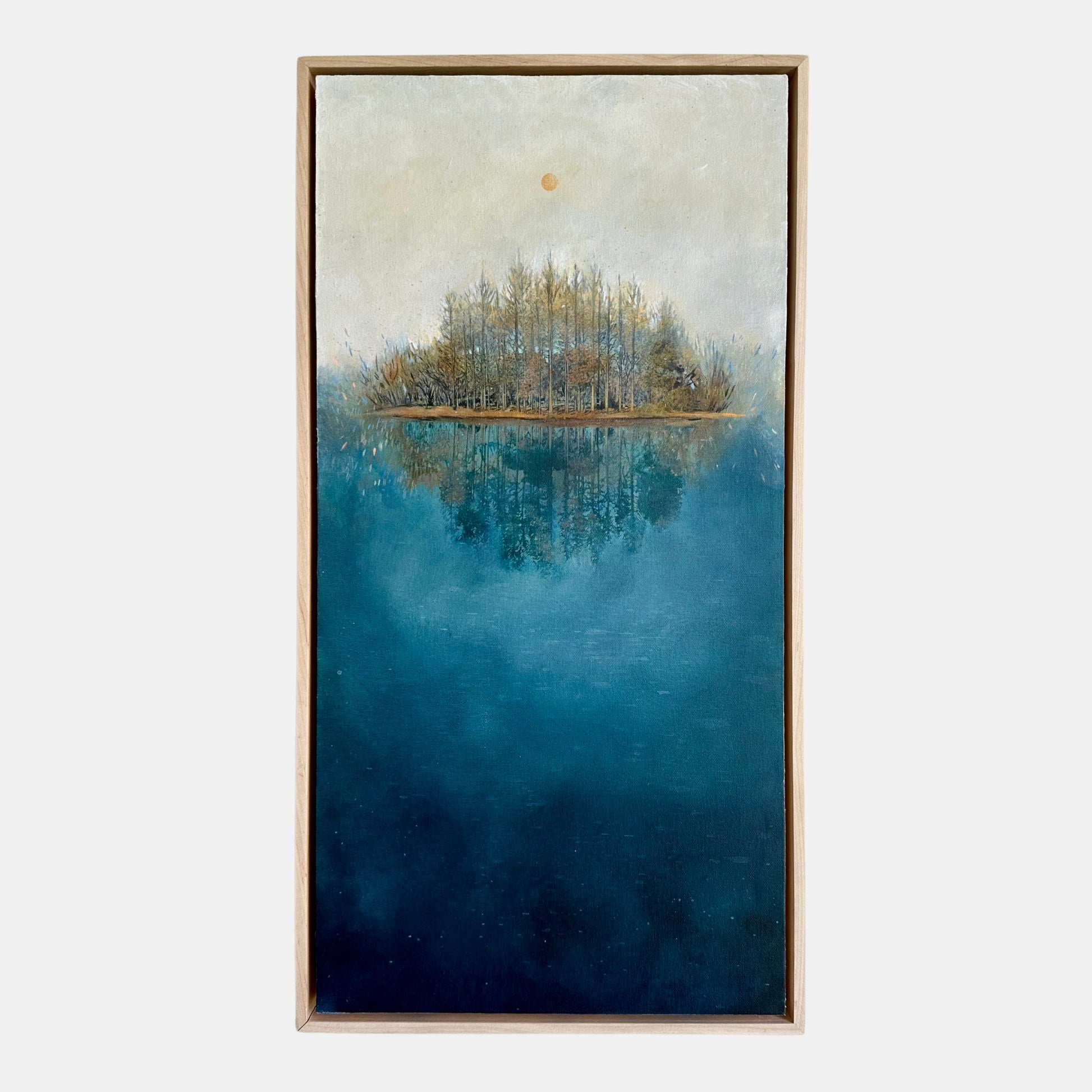 Framed artwork of a serene landscape with trees on an island in the middle of a blue body of water.